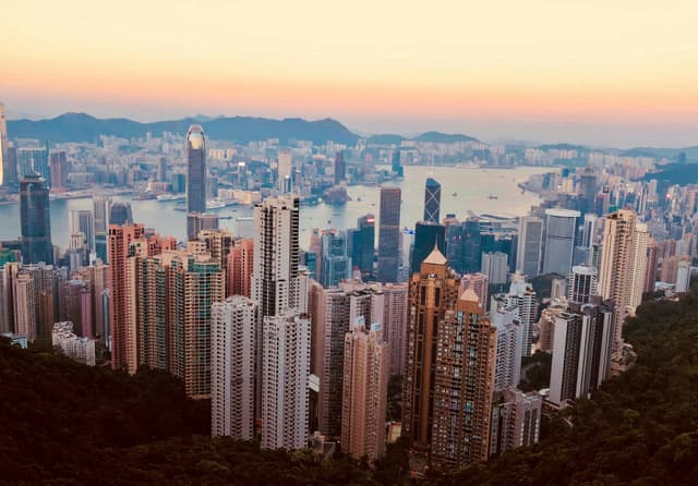 Breathtaking Kowloon skyline with skyscrapers and harbor at sunset, showcasing Hong Kong's urban beauty.