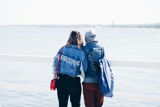 A couple in denim enjoys a peaceful moment by the sea in Gdynia, Poland.