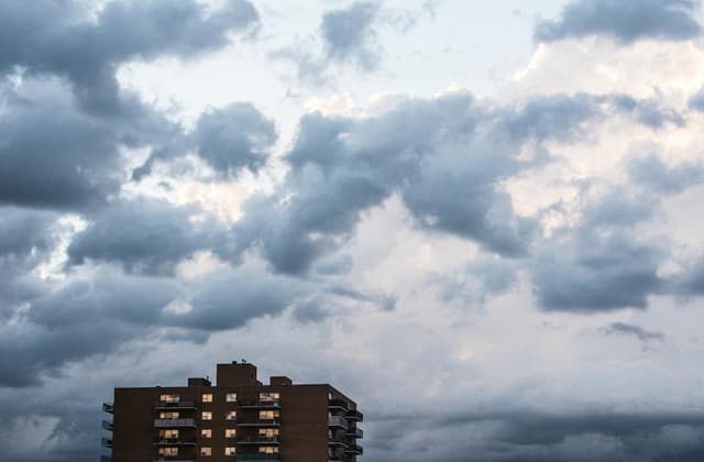 Dramatic clouds over an apartment building in Winnipeg, Canada, creating a moody urban landscape.