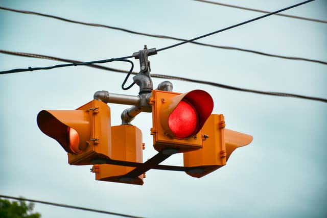Detailed image of a red traffic light against a clear sky in Guelph, Ontario.