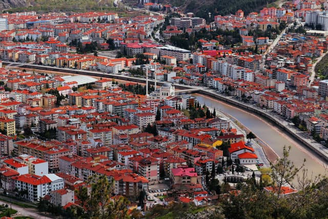 Aerial view of Amasya cityscape featuring the Yeşilırmak River and mosque amid urban landscape.