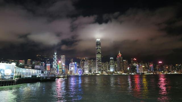 Breathtaking view of Hong Kong's skyline reflecting on the waterfront at night.