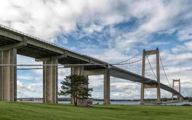 Modern suspension bridge spanning a scenic landscape in Denmark, ideal for travel and architecture themes.