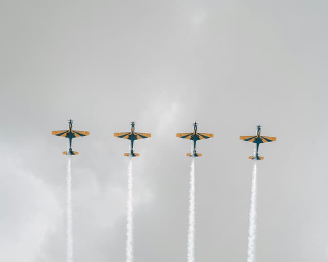 Dynamic aerobatic display with four airplanes performing in a synchronized air show.