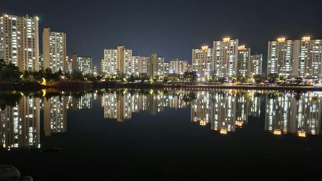 Stunning night view of illuminated buildings reflecting on a calm lake in Gimpo-si, South Korea.