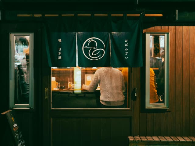A view from outside a cozy urban café in Toyohashi, Japan, capturing the ambiance and design.