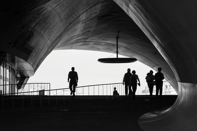 Silhouetted figures in a modern architectural walkway. Kaohsiung City, Taiwan.