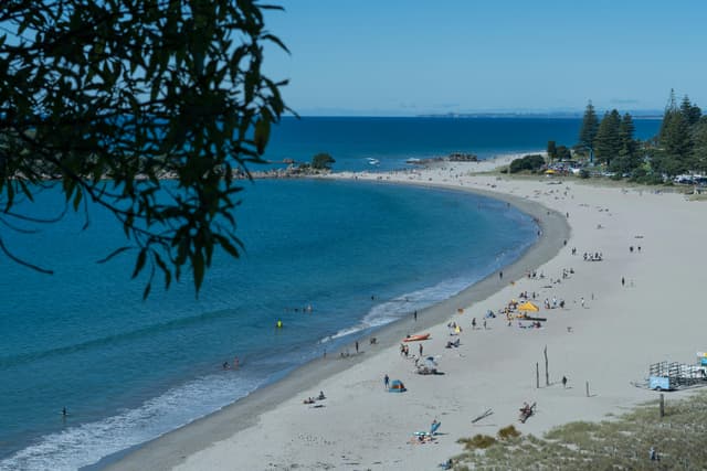 Stunning aerial view of a sunny beach at Mount Maunganui, New Zealand, perfect for leisure and relaxation.