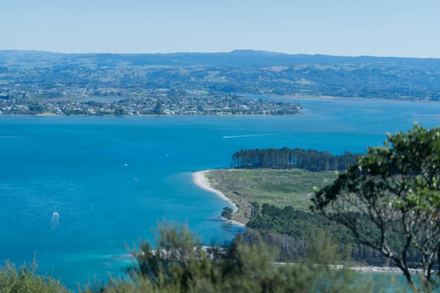 A stunning aerial view of Mount Maunganui with its turquoise waters and lush greenery in New Zealand.