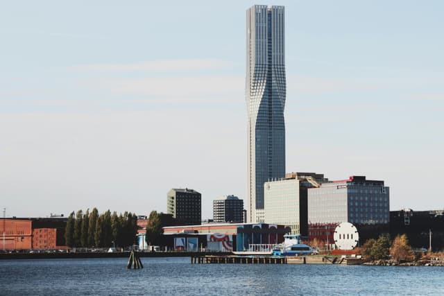 A scenic view of Gothenburg featuring a modern skyscraper by the water.