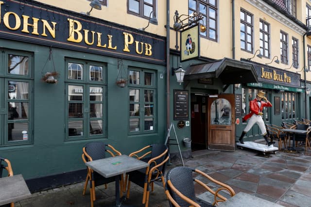 Street view of the historic John Bull Pub in Aalborg, Denmark, showcasing its quaint architecture.