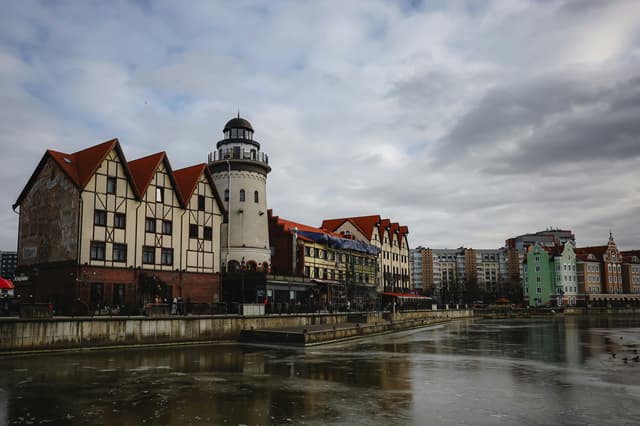 Charming European architecture by the waterfront under a cloudy sky.