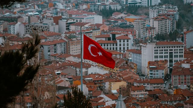Aerial view of Afyonkarahisar city with the Turkish flag prominently displayed.