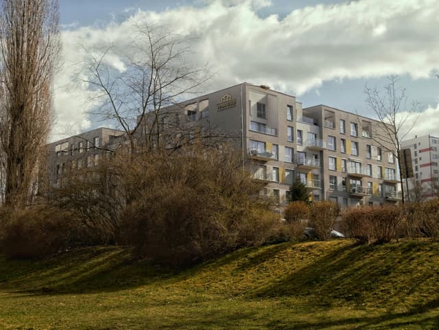 Contemporary apartment complex amidst landscaped greenery in Zielona Góra, Poland.