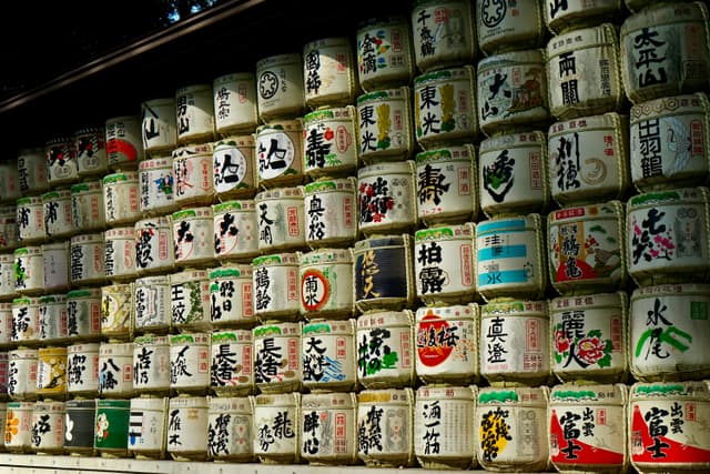 A wall of colorful sake barrels at Meiji Shrine, Tokyo, showcasing Japanese culture and tradition.