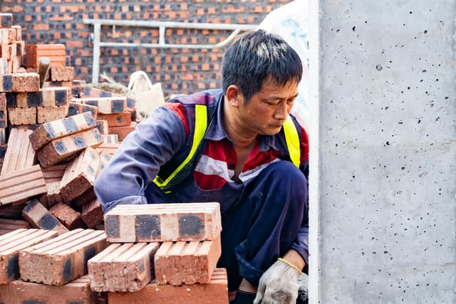 Focused worker laying bricks at construction site in Hải Phòng.