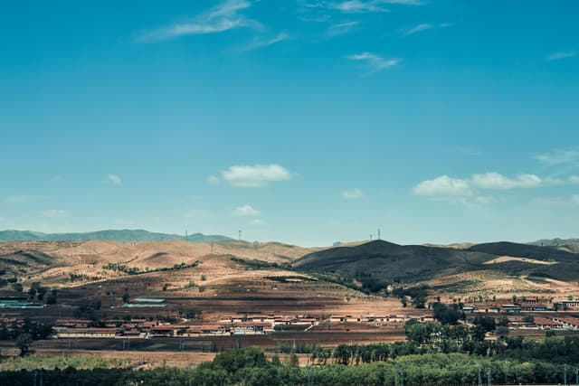 A picturesque view of rolling hills and blue sky in Hohhot, Inner Mongolia, China.
