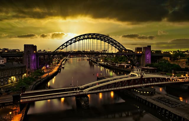 A captivating sunset view of the Tyne Bridge in Newcastle with vibrant reflections on the river.