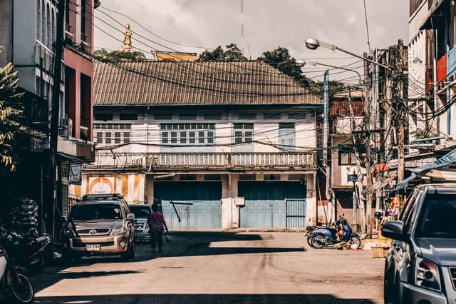A bustling street scene in Tambon Thap Thiang, Thailand, showcasing traditional architecture and urban life.