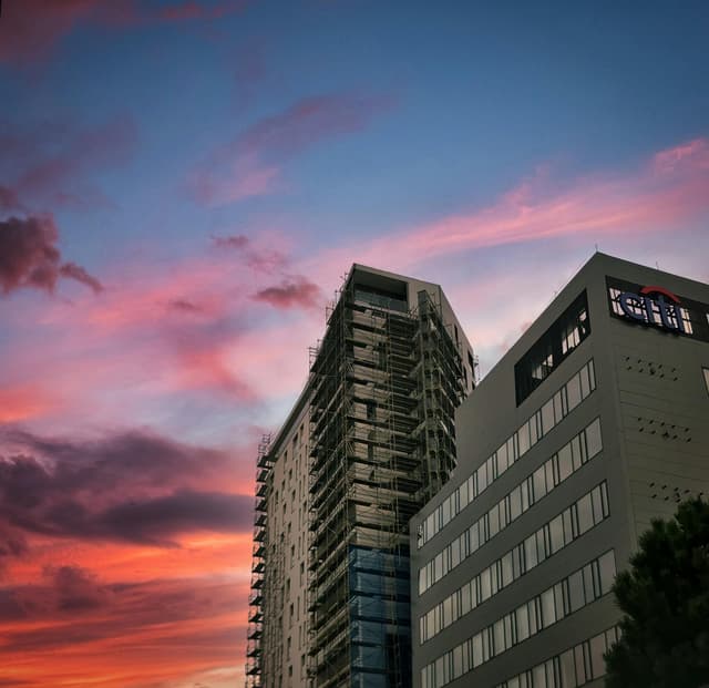 Olsztyn cityscape featuring modern buildings against a vibrant twilight sky.