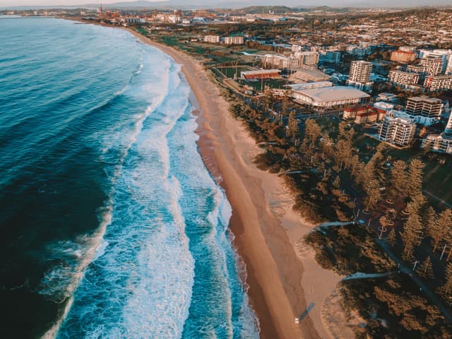 Stunning aerial shot of Wollongong Beach with city buildings in NSW, Australia.