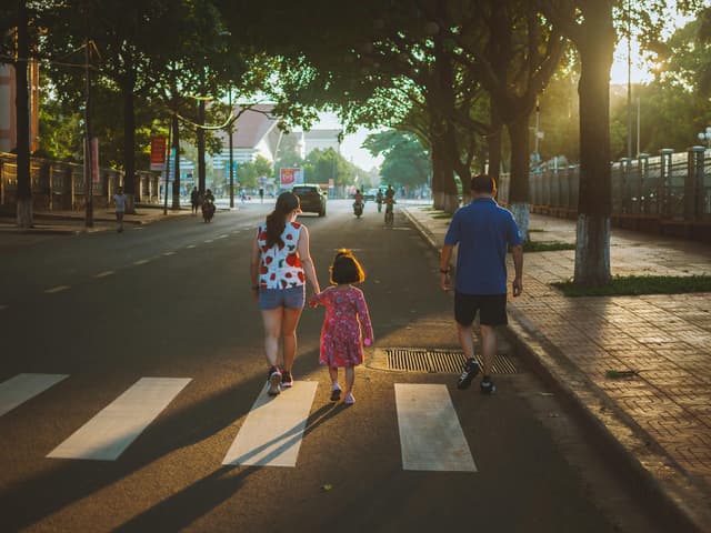 Family walking on a sunny day in Buon Ma Thuot. Warm, relaxed moment captured in Vietnam.