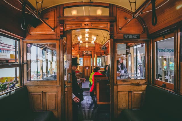 Explore the charming interior of a vintage tram in Christchurch, New Zealand with passengers aboard.